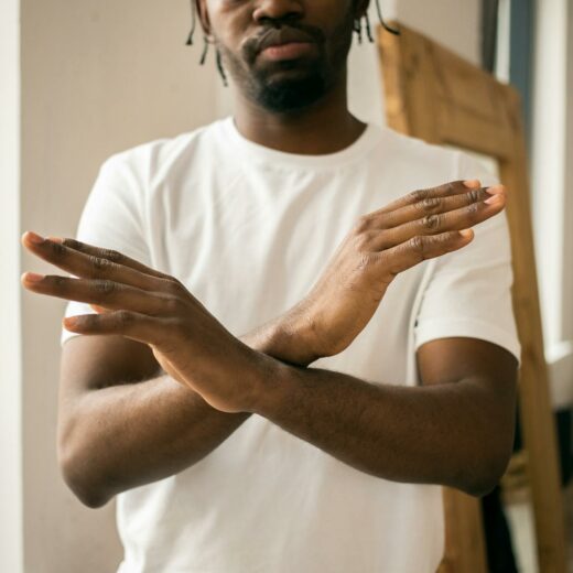 faceless black man showing stop gesture with crossed hands