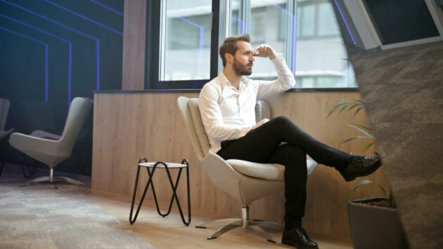 photo of a man sitting near the windoww