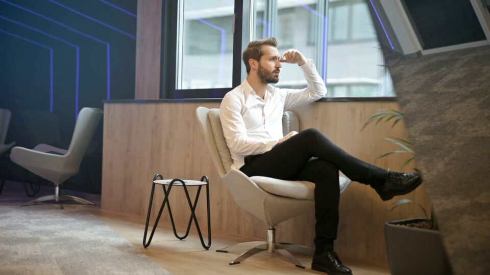 photo of a man sitting near the windoww