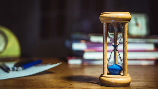 hourglass on brown wooden frame